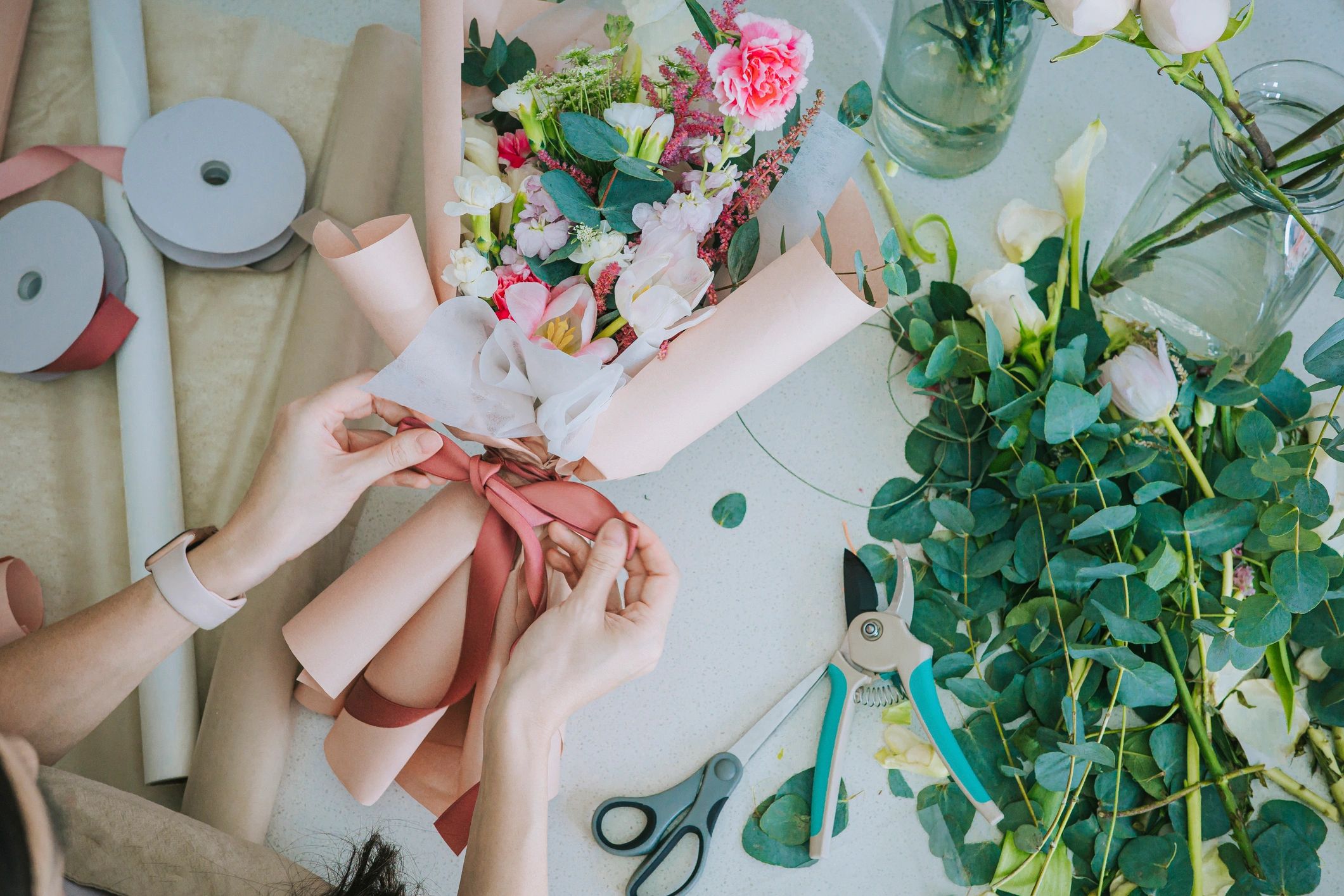 Top-down view of florist wrapping a bouquet